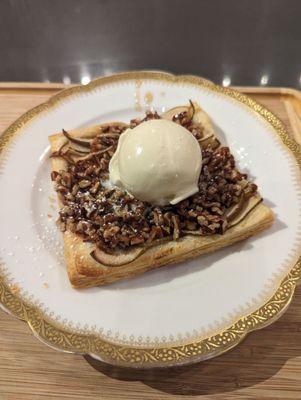 Pears on puff pastry topped with ice cream.