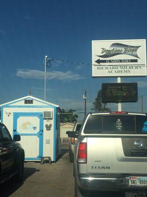 Little shack in parking lot underneath daytime bingo sign