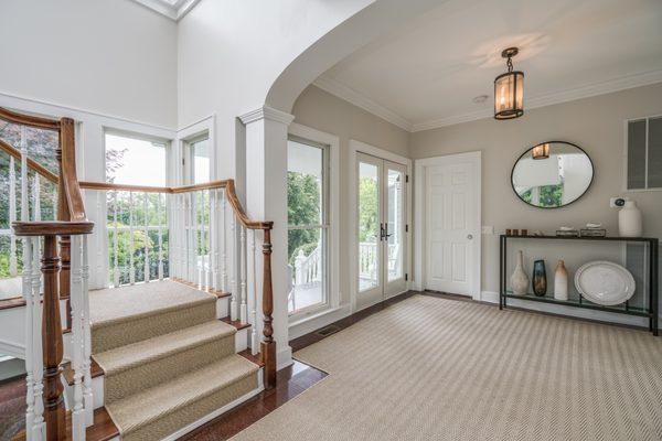 Elegant, trimmed living room with luxury staircase, furnished.