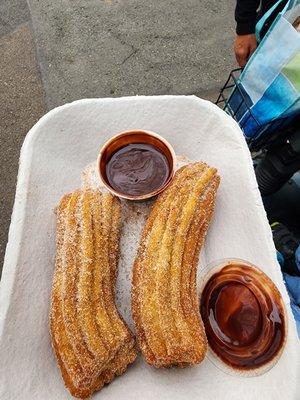 Two churros with chocolate sauce