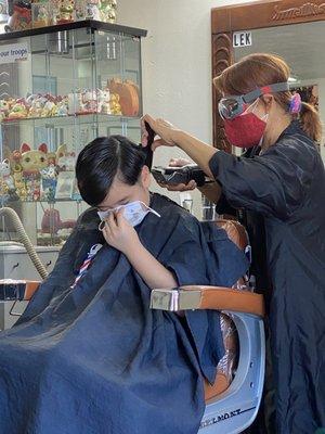 Lek practicing safe haircut procedures amid pandemic. She always wants your mask on at all times.