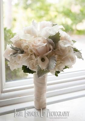 All White Bridal Bouquet with Roses, Miniature Calla Lilies, Hydrangea and more with nestled leaves of Dusty Miller.