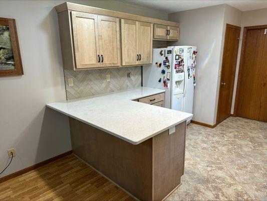 Refacing project with new maple doors, quartz countertops, and tile backsplash.