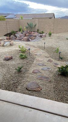 Beautiful natural stone path way that leads to a sitting area next the a pondless stream.