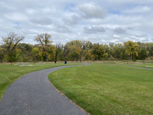 Green grass and paved trail.