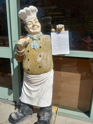 Chef statue holding weekly menu