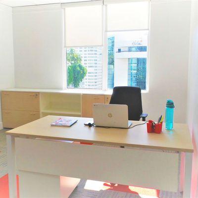 Big office for six people with desks, cabinets and two windows with ocean and city view