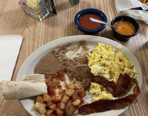 Huevos Rancheros plate with bacon and sausage.