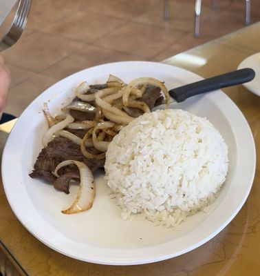 Stake with onions on top, side rice