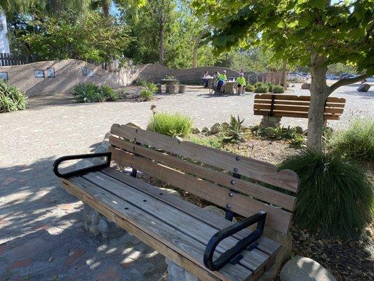 Bench and picnic tables in distance.