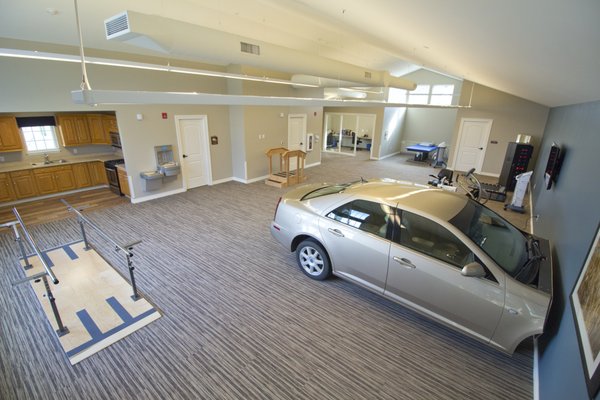 The therapy gym features state of the art rehab equipment, a full kitchen, full residential bath, and a Cadillac sedan for rehab treatments.