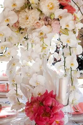 Cascading white Phalaenopsis Orchids high centerpiece for an all white Birthday Party event with some hot pink Peonies