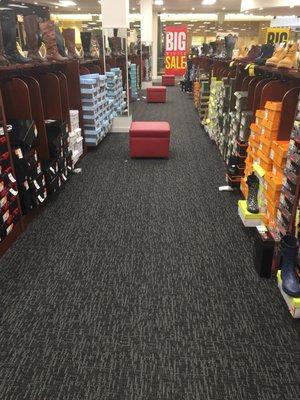 Multiple ottomans in nearly every aisle for trying on shoes.