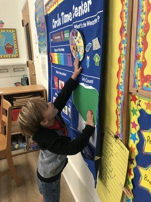 Our class helper gets an opportunity to show us what the weather is.