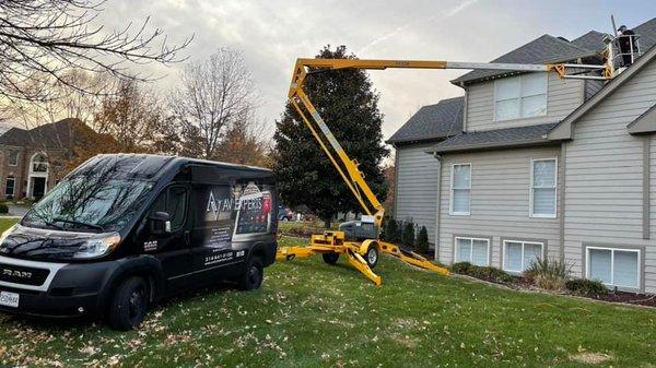 Using a lift to install a surveillance system on this large home.