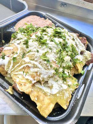 Madre's Chilaquiles Verdes with Steak and topped with 2 over easy eggs