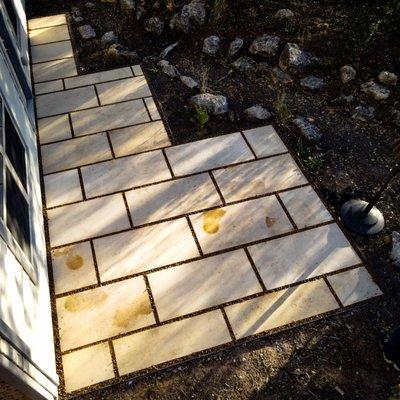 Limestone patio with granite gravel and steel-welded borders and a ephemeral stream for erosion control and water runoff.