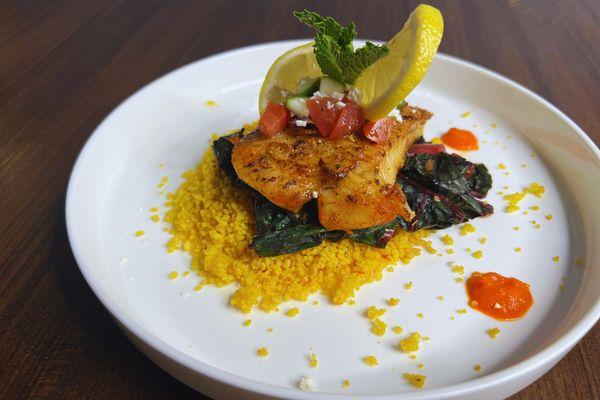 Mediterranean filet of sole topped with tomato feta relish, sautéed Swiss chard, spiced cous cous