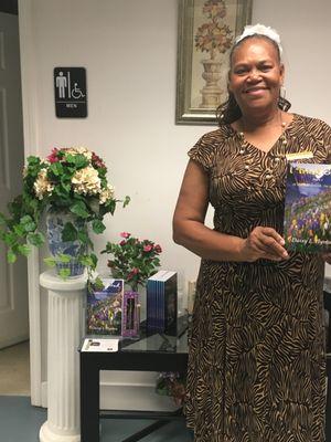 A picture of the owner of the church holding her book that she's worked so hard on.