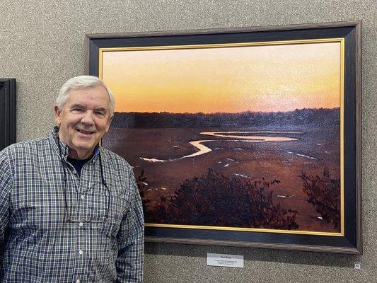 Paul George and his award-winning painting "Sunset Marsh" at the George Morse Gallery