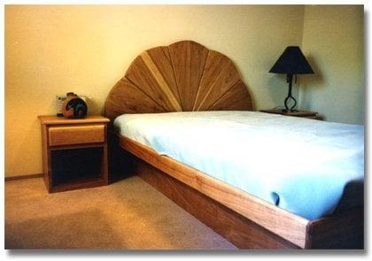 A platform bed with a peacock style headboard