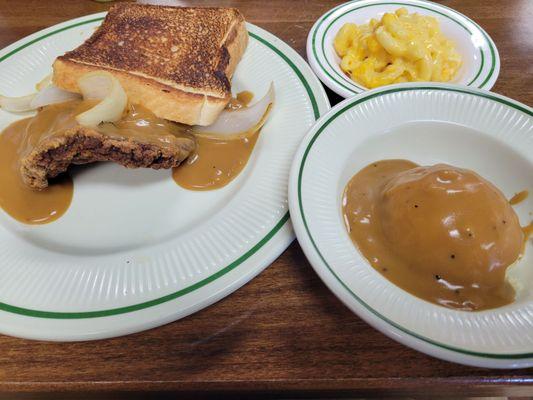 Country fried steak with brown gravy and onions and Texas toast. Mashed potatoes and brown gravy with macaroni and cheese.