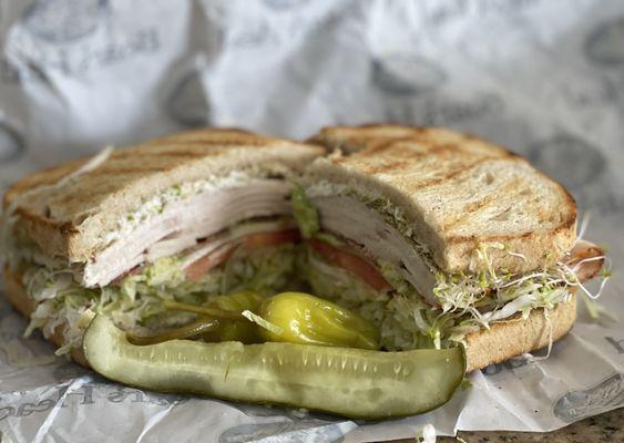 Cali Club on toasted sourdough: Turkey, avocado, bacon, alfalfa sprouts, lettuce, tomato, mayo, salt &pepper with pickle and peppers