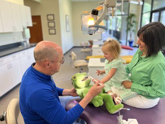 Dr. Caple coaches a patient on oral hygiene and brushing techniques with a favorite "dental assistant", Mr. Frog.