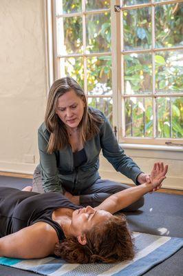 Movement instructor guiding a student in a Clinical Somatics exercise to relieve shoulder pain