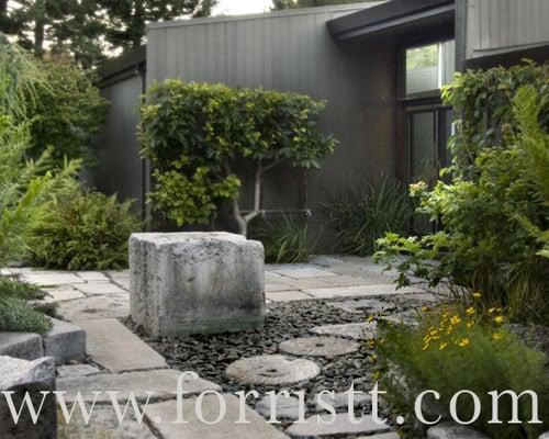 Water stone set into a natural reclaimed Sierra granite path inset with antique Asian mill stones