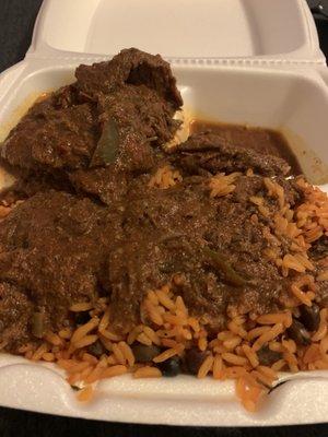 Beef stew over rice with beans.