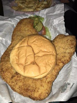 Breaded pork tenderloin with condiments and a side