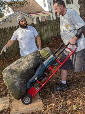 Buddha on appliance dolly being moved across the yard.  This is VERY heavy, Bill making it look much easier than it was.