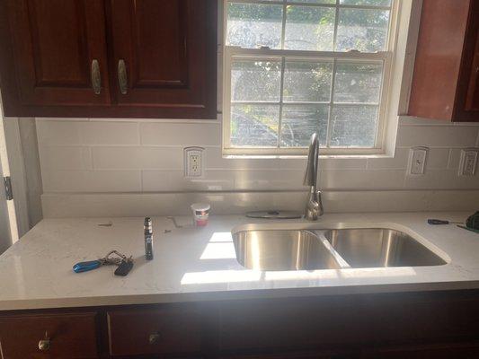 Kitchen backsplash tiled and new faucet and garbage disposal installed