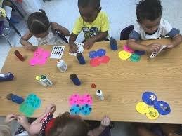 Children begin their day in small groups with a centering activity working on patterns, motor skills and following project instruction