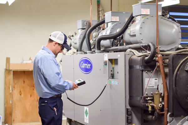 HVAC technician performing routine checks on a commercial chiller unit.