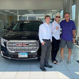 Kylan and his clients with their purchased vehicle.