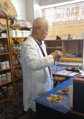 Dr. Gao preparing an herbal prescriptions.  All prescriptions are custom based on a  patients' needs.