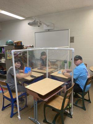 Kiddos safely taking a break from masks at their desks.