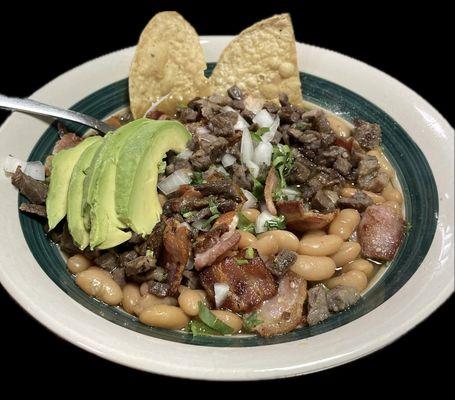 Carne en su jugo 
Bean soup season and top with fresh grilled asada meat bacon and green tomato souse