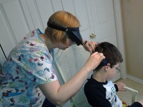 LiceDoctors technician checks for lice and nits (eggs) in her client's hair.