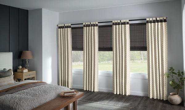 Natural shades layered with decorative drapery panels