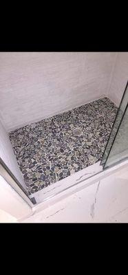 Ceramic tile in the bathroom with stones on the floor