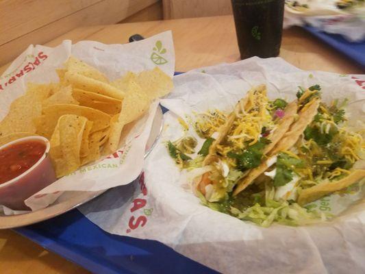 Hard shelled tacos with shrimp verdant sauce, cilantro and cheese.