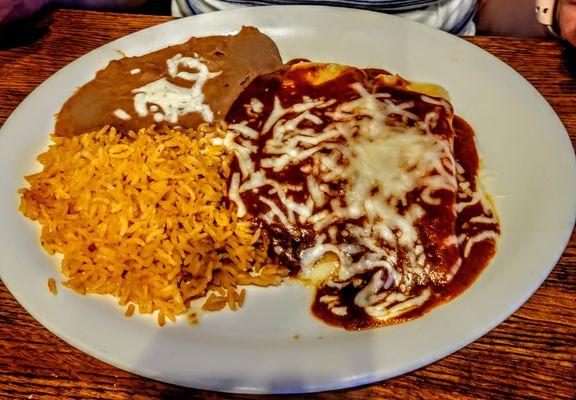 Cheese Enchiladas with rice and refried beans and covered in Mole sauce.