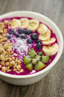 Colorful acai bowl topped with granola, kiwi, blueberry, banana and coconut shreds!