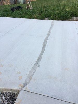 This crack happened less than 24 hours from the pour. The picture is after they "fixed" it. It cracked more the first time a car drove on it