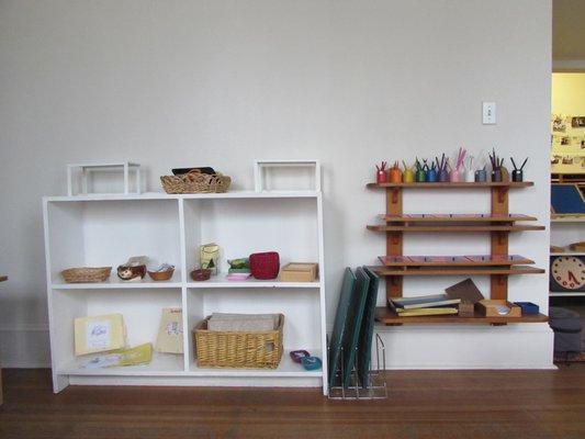 Shelves filled with works are integral to the Montessori method. Here we see self expression and language works available for children.