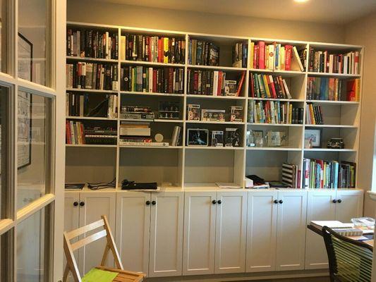 Home office wall unit with storage and book display cases.