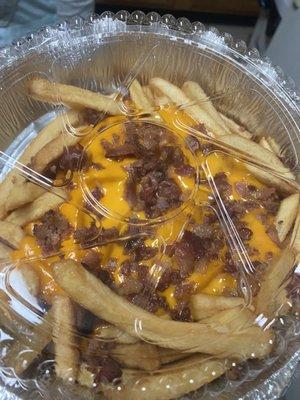 Order of Large Bacon Cheese Fries that barely cover the bottom of the container.